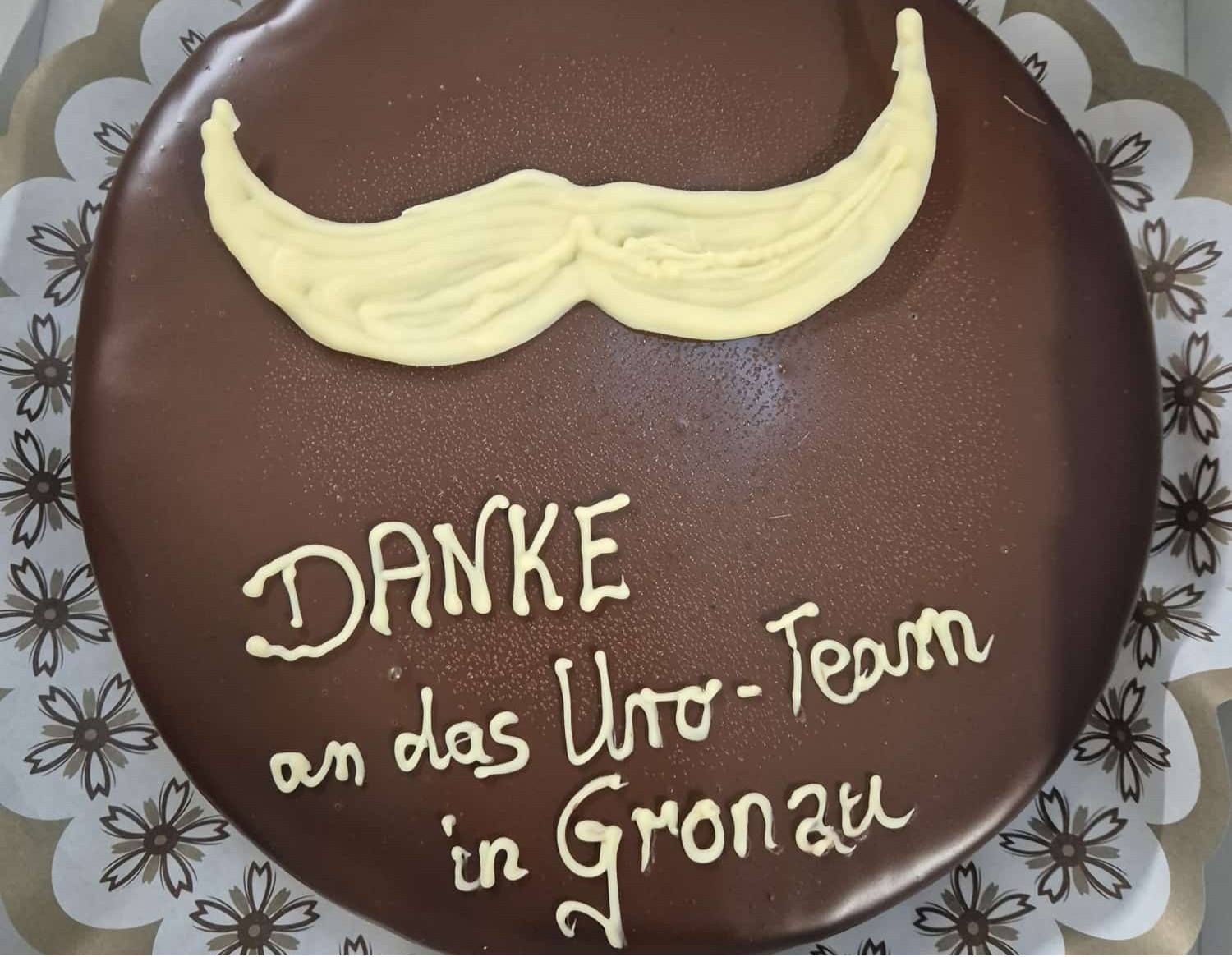 Herrentorte mit Glasur-Aufschrift: Danke an das Uro-Team in Gronau plus Moustache-Zeichen. 